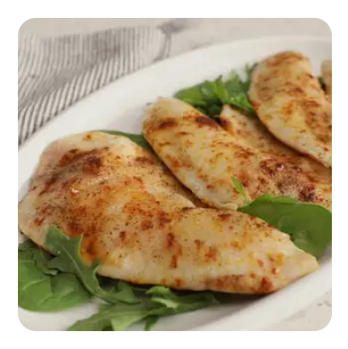 Baked tilapia filets over a bed of greens