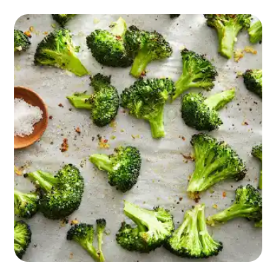 Seasoned broccoli on parchment paper Seasoned broccoli on parchment paper