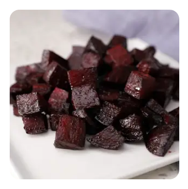 Chunks of roasted purple beets on a white plate