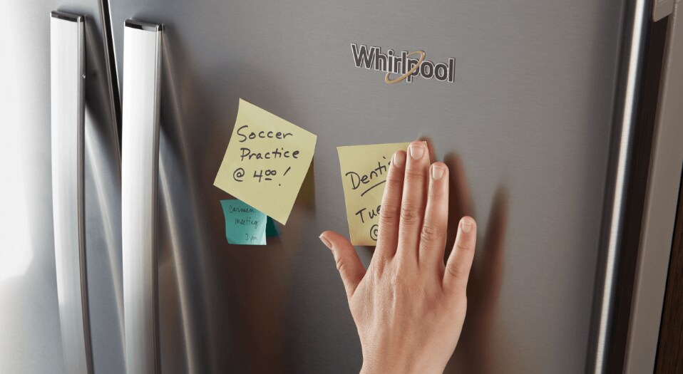 A person putting sticky notes on a Whirlpool® fridge A person putting sticky notes on a Whirlpool® fridge