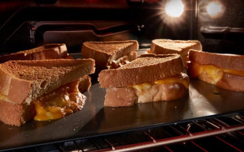 Grilled cheese on a pan under a broiler