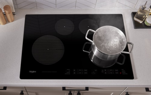 A pot of water boiling on an induction cooktop