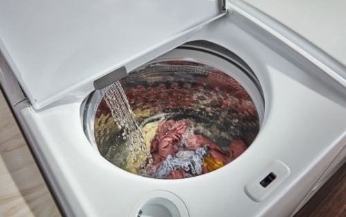An open washer filling with water