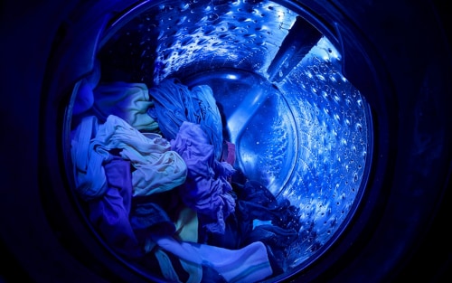Inside a Whirlpool®  Washer basket with UV Clean Technology shining a blue UV light