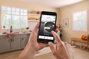 Hand holding a smartphone showing a laundry app with cycle progress