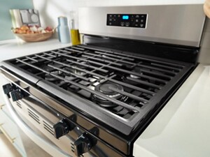 Close up of a gas stovetop showing cast iron grates and gas stove burners