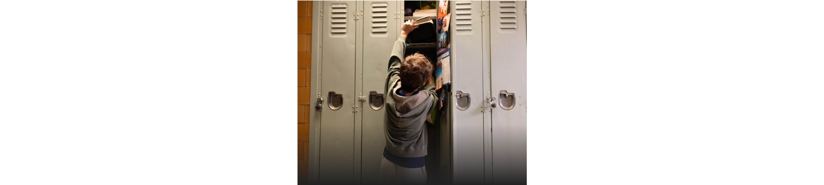 A child reaching for a book in a locker