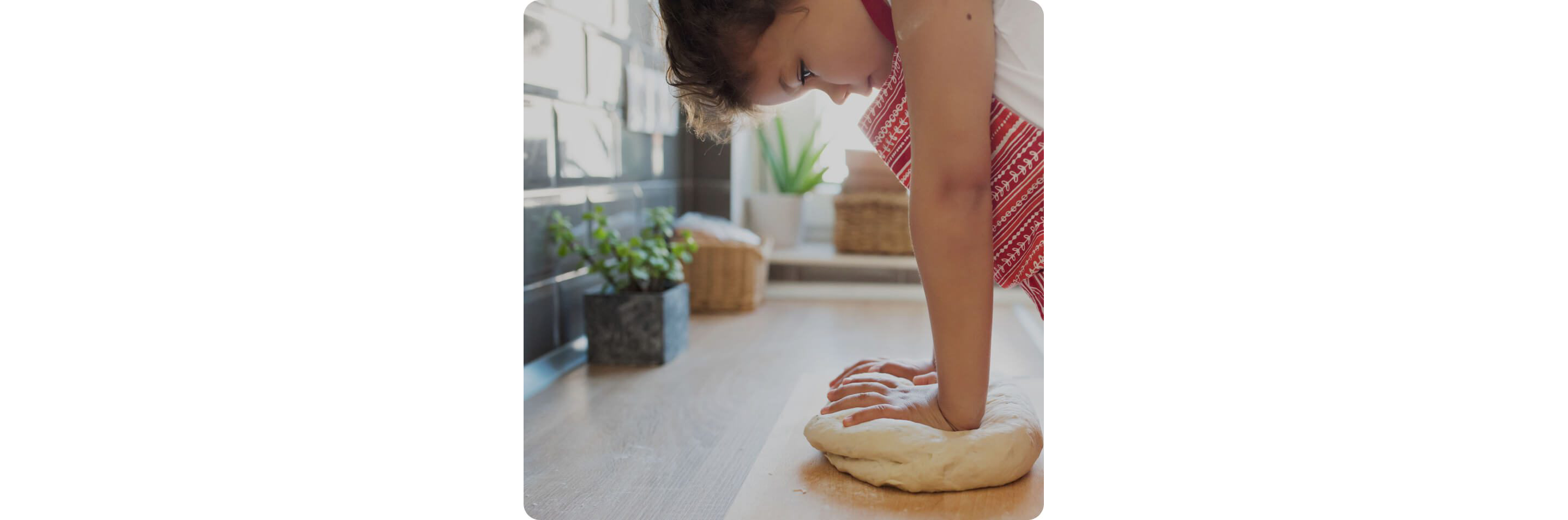 A child kneading dough on a kitchen countertop