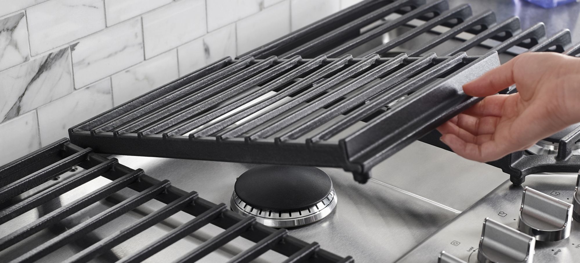 Des tables de cuisson au gaz avec des grilles qui se soulèvent pour faciliter le nettoyage.