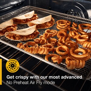 Whirlpool oven interior with crispy fries and tacos cooking on an air fry basket, promoting No Preheat Air Fry mode