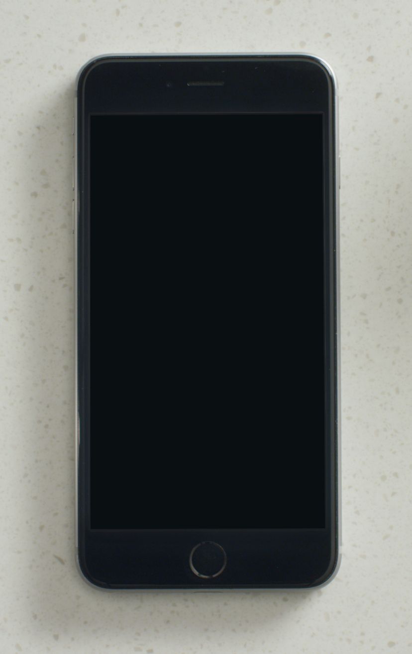A smart phone with the Whirlpool app on the screen, sitting on a countertop surrounded by baking supplies.