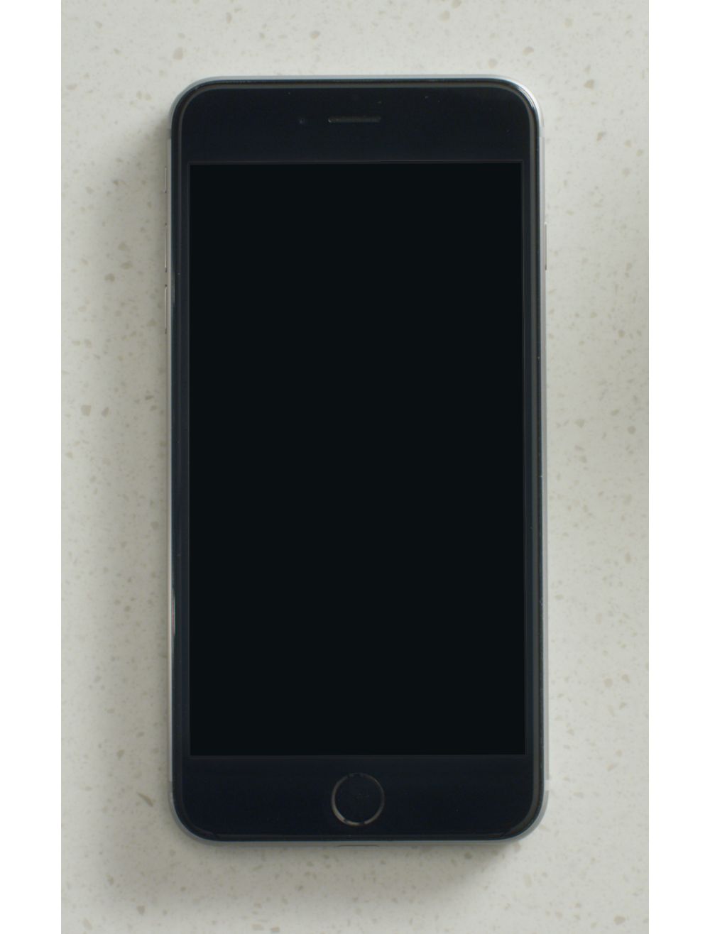 A smart phone with the Whirlpool app on the screen, sitting on a countertop surrounded by baking supplies.