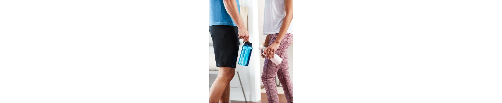 Deux personnes en tenue de sport tiennent leurs bouteilles d'eau réutilisables