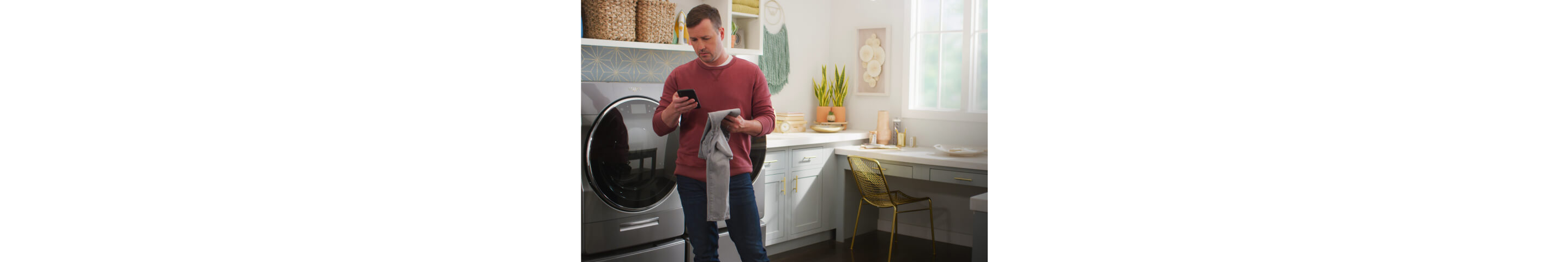 A person holding a smartphone in the laundry room with the home heartbeat blog logo