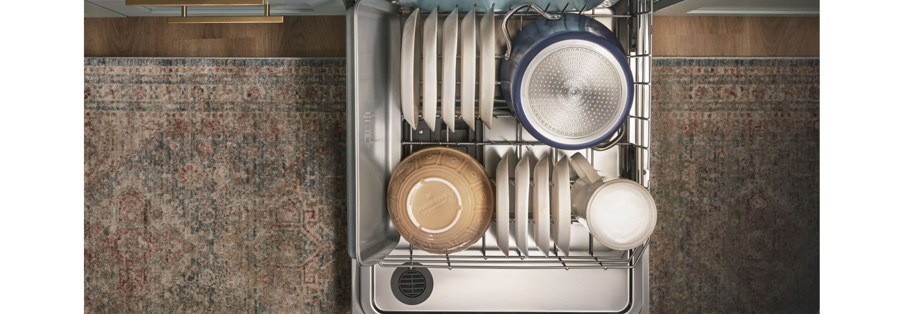 A top-down view of a fully loaded bottom rack of a dishwasher