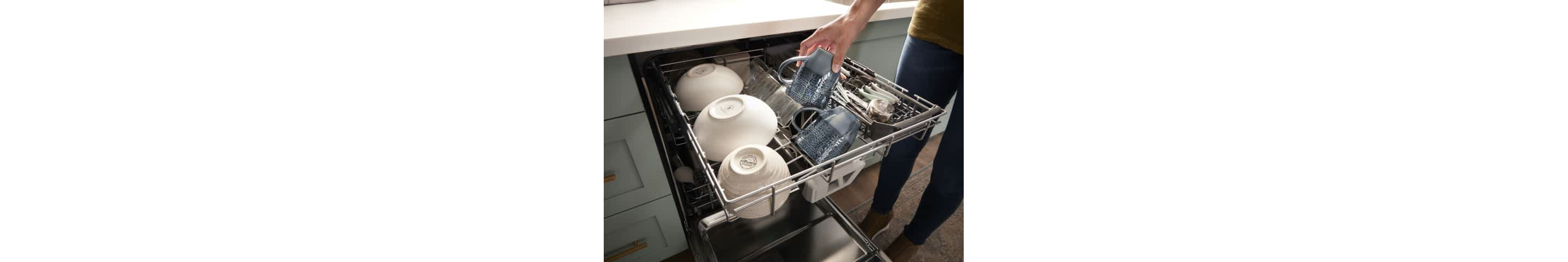 A hand loading a coffee mug in the 3rd Rack with Extra Wash Action