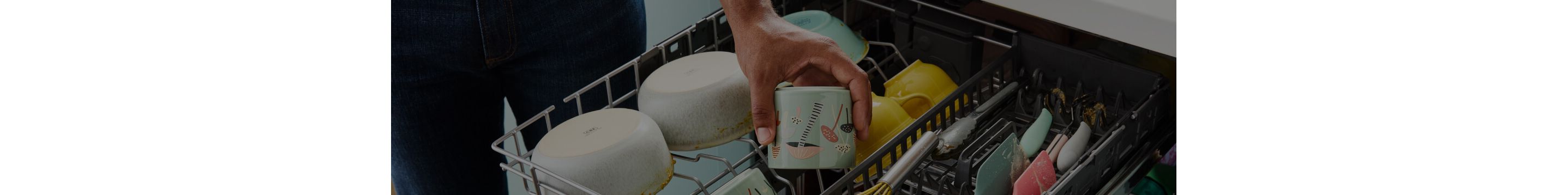 A person putting a cup inside of a Whirlpool® 3rd Rack Dishwasher