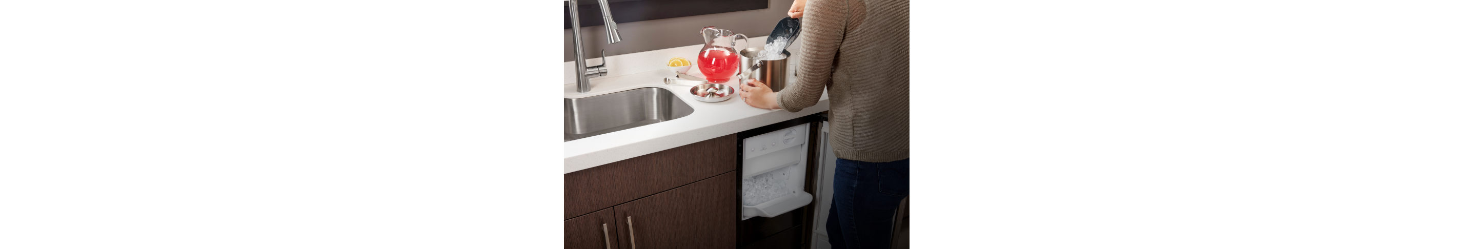 A person placing ice into an ice bucket