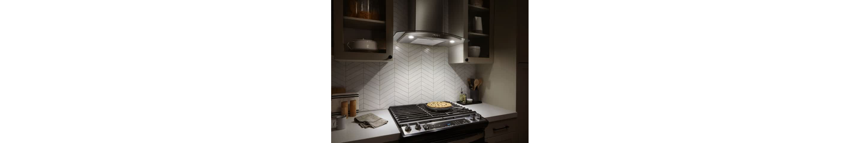 LED Task Lighting from a Whirlpool® Canopy Hood shines down on a cooktop