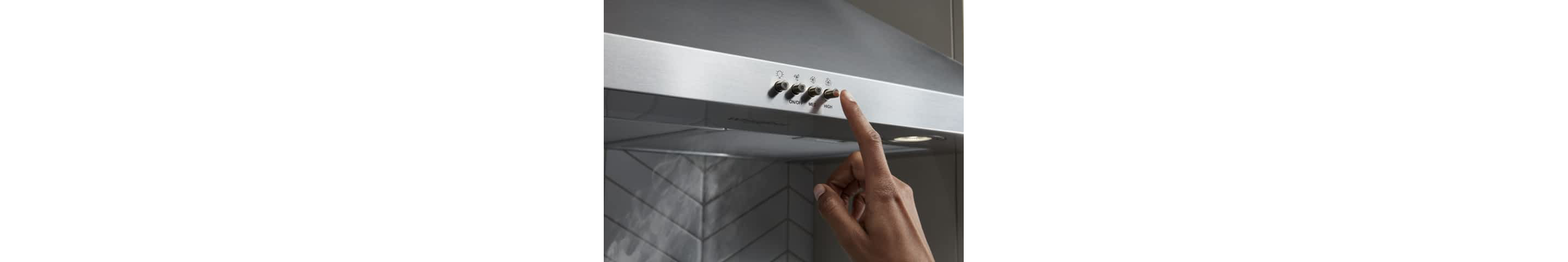 A hand pressing the venting button on a Whirlpool® Canopy Hood