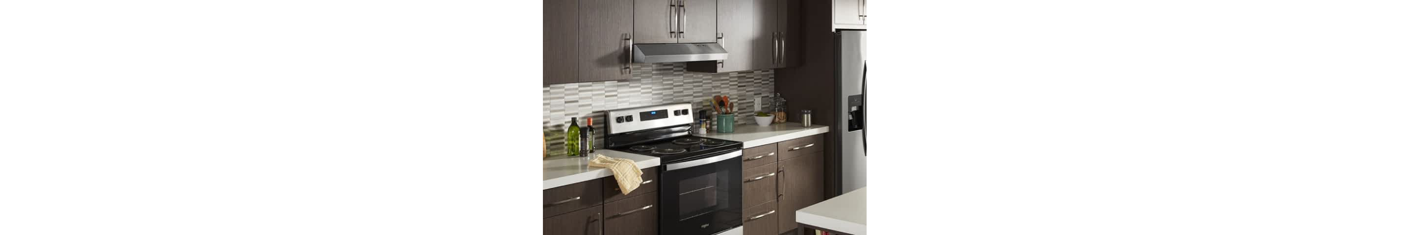 A Whirlpool® Undercabinet Hood in a kitchen with brown cabinets