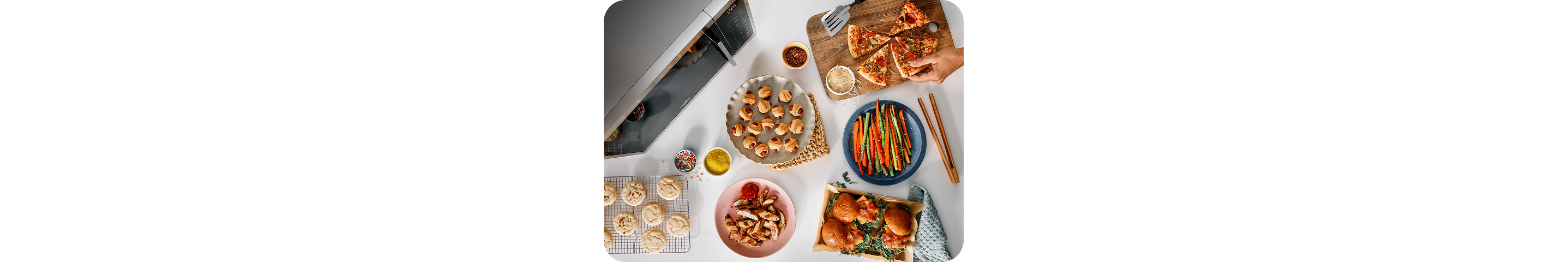 An overhead view of a variety of snack plates next to a countertop microwave