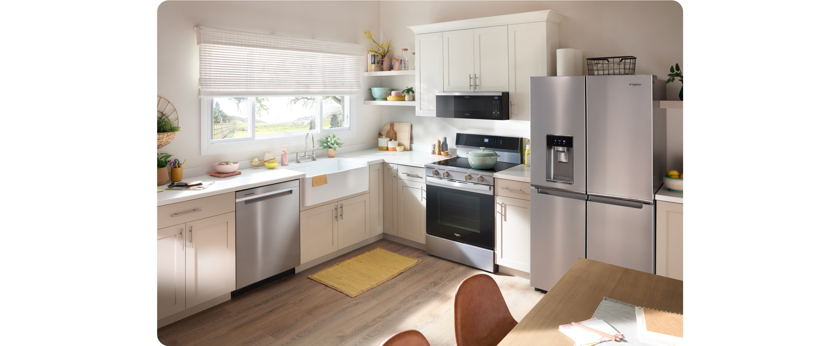 A kitchen with stainless steel Whirlpool® appliances and blue cabinets