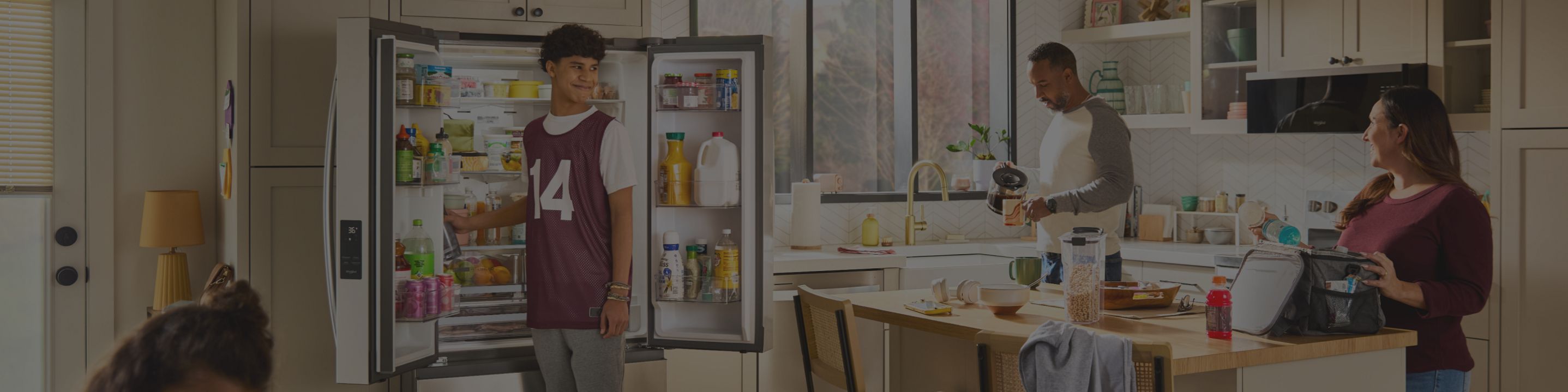 A family removing food from an opened French door refrigerator while preparing lunch