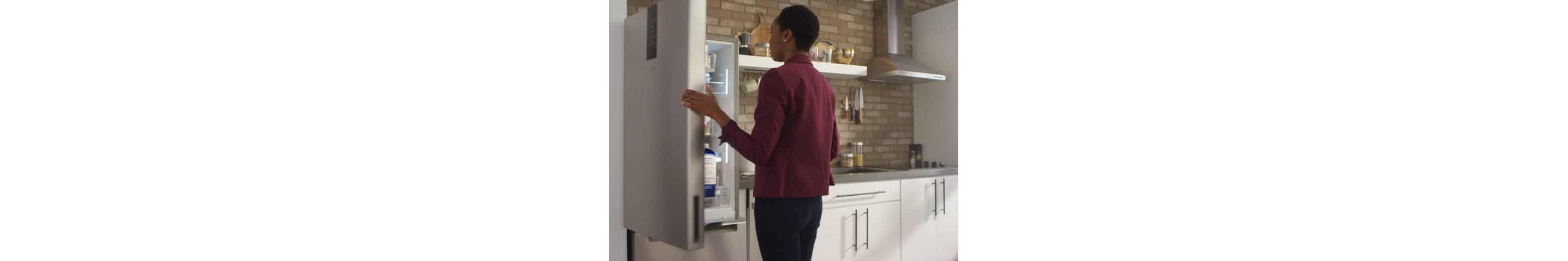 A woman opens a Whirlpool® Bottom Freezer Refrigerator with a Fingerprint-Resistant Stainless Finish