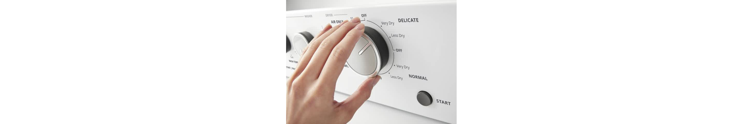 A hand turns a knob on a Whirlpool® Stacked Laundry Center