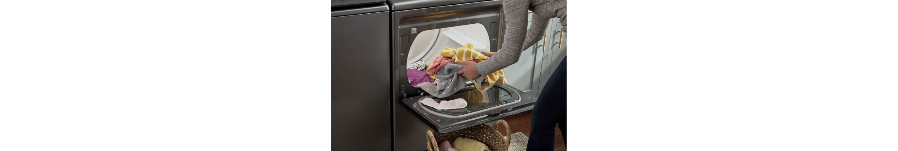 A person unloads laundry from a Whirlpool® Front Load Dryer