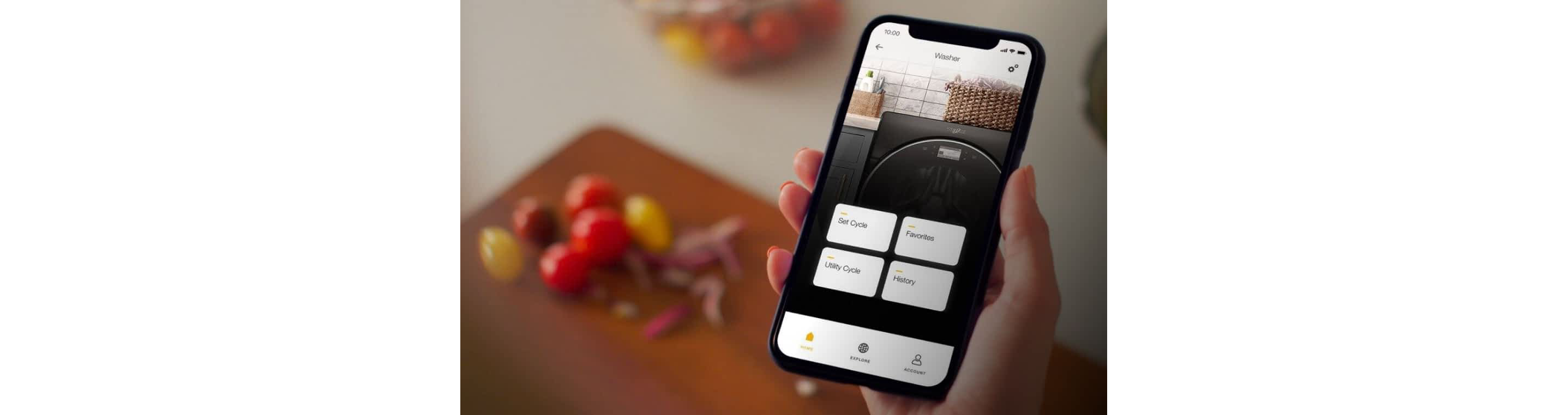 A hand holding a phone displaying the Whirlpool® App