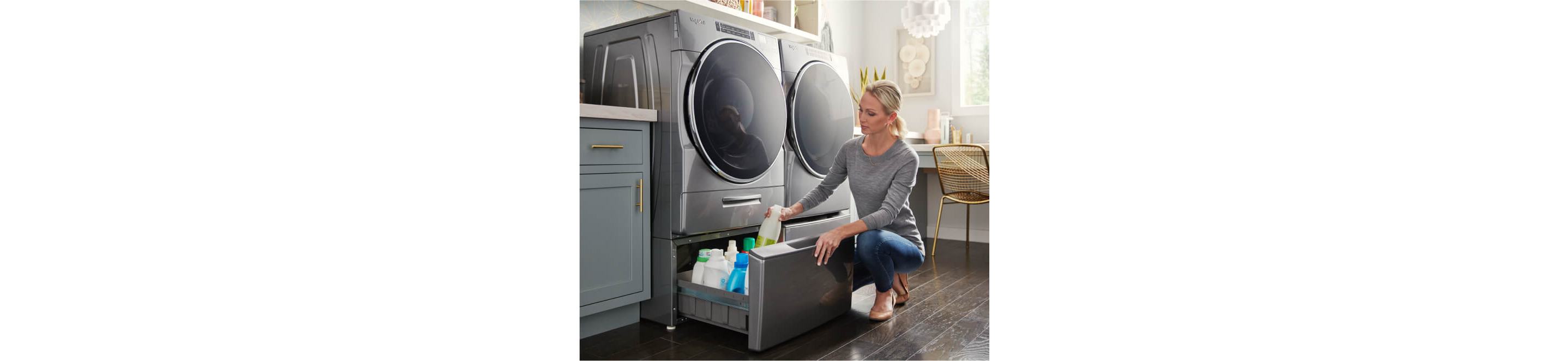 A Whirlpool® Front Load Washer and Dryer side-by-side on top of laundry pedestals