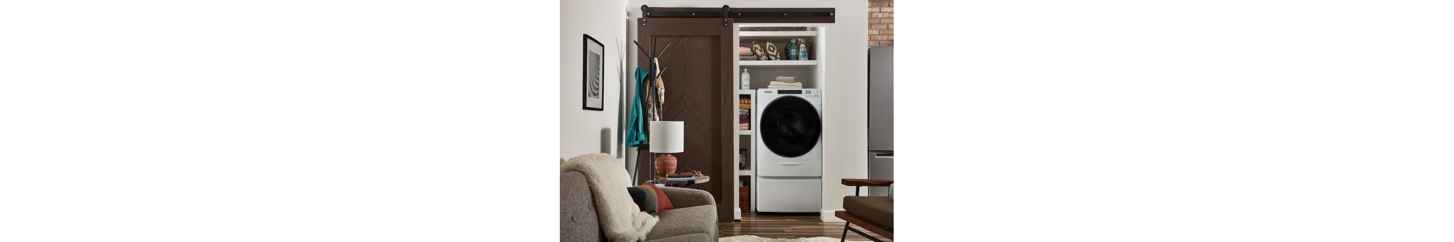 White Whirlpool® All-In-One Washer & Dryer inside of a closet with a sliding barn door