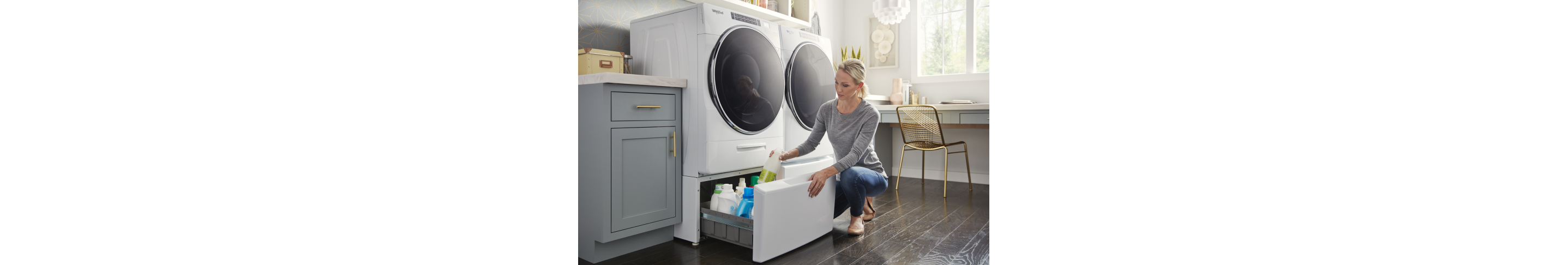 A person putting an item into a pedestal drawer on a Whirlpool® Front Load Washer