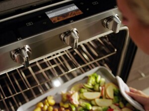 Someone pulling a sheet pan of food out of an oven