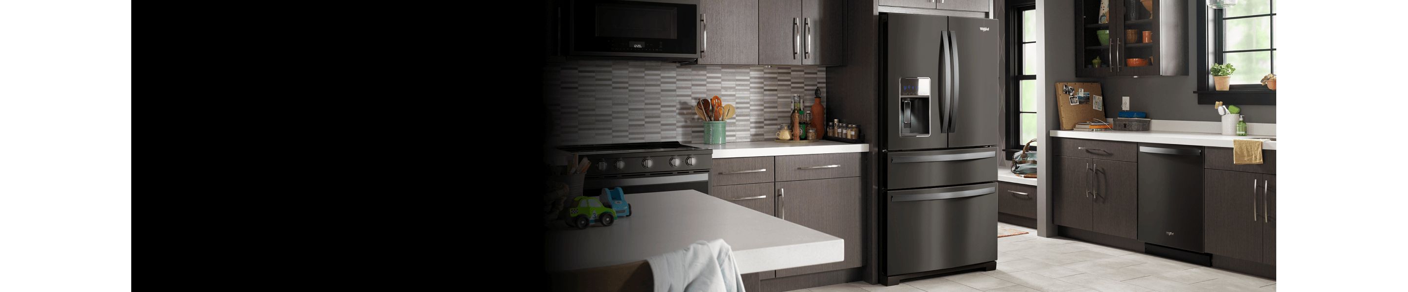 A black stainless steel refrigerator in a kitchen with other appliances.