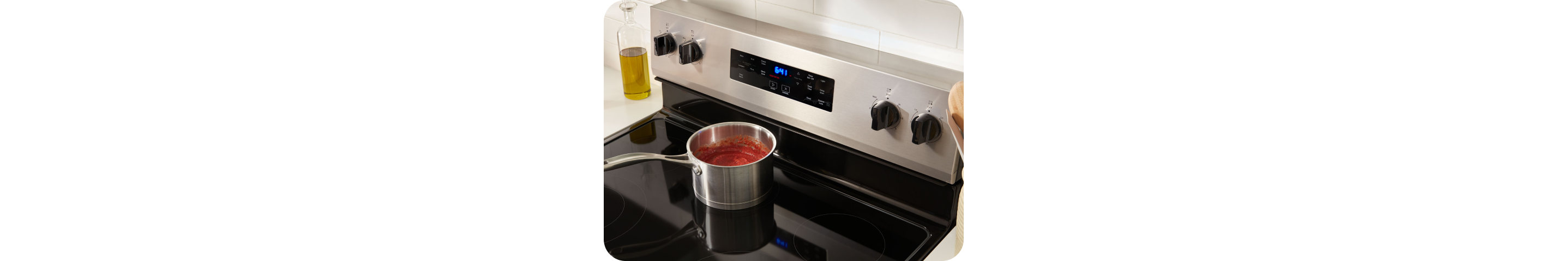 A pot a pasta sauce simmering on a stovetop.
