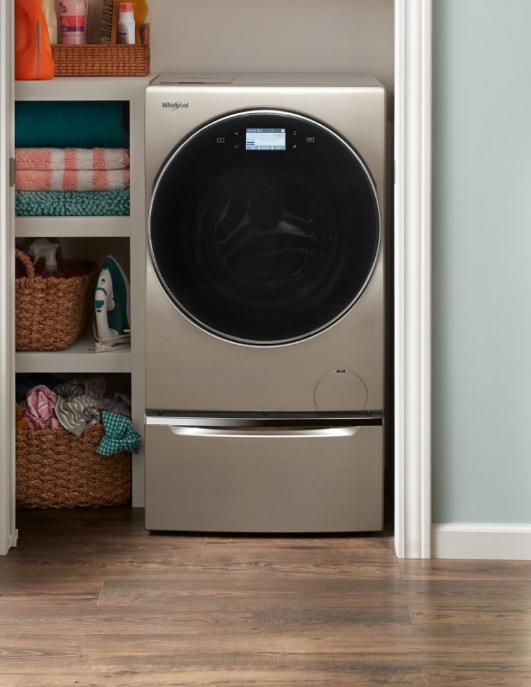 An all-in-one washer/dryer in a laundry closet.