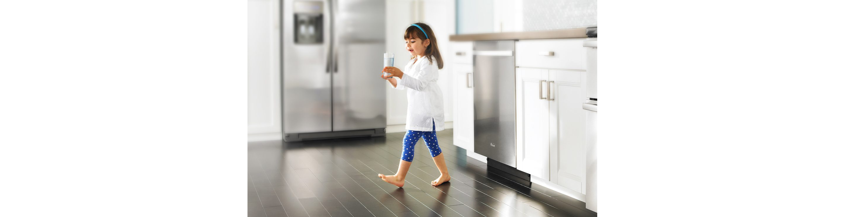 A girl carrying a glass of water.