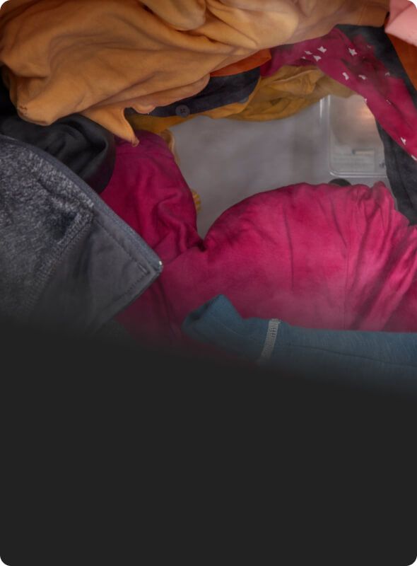 Clothes tumbling in a dryer with steam