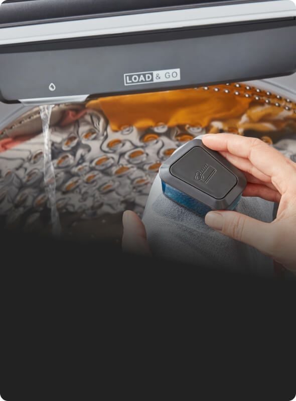 Using the pretreat brush to treat a stain over the washer