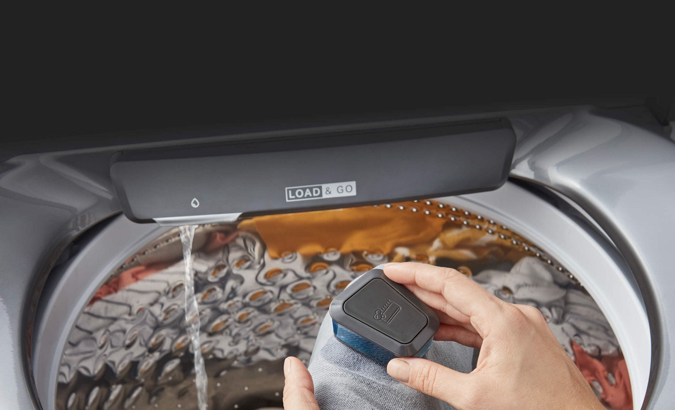 Scrubbing clothes with the pretreat brush and rinsing in the built-in faucet on a Whirlpool® Washer with Pretreat Station