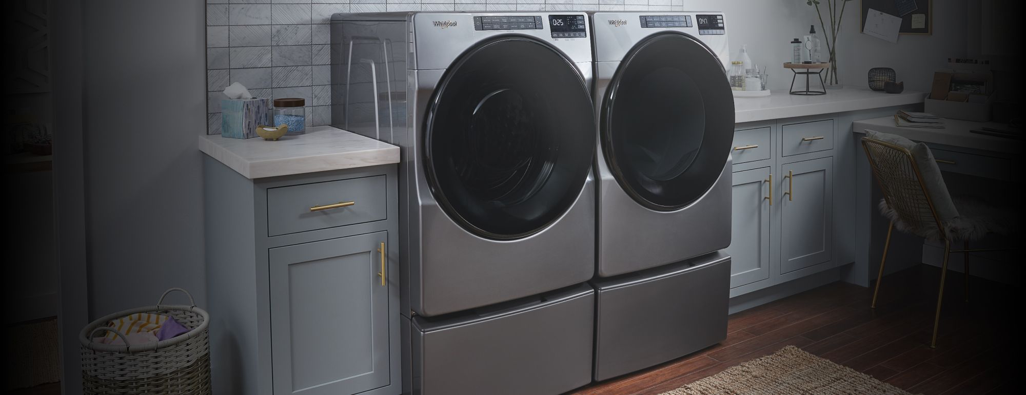 A front load washer and dryer set on pedestals in a laundry room.