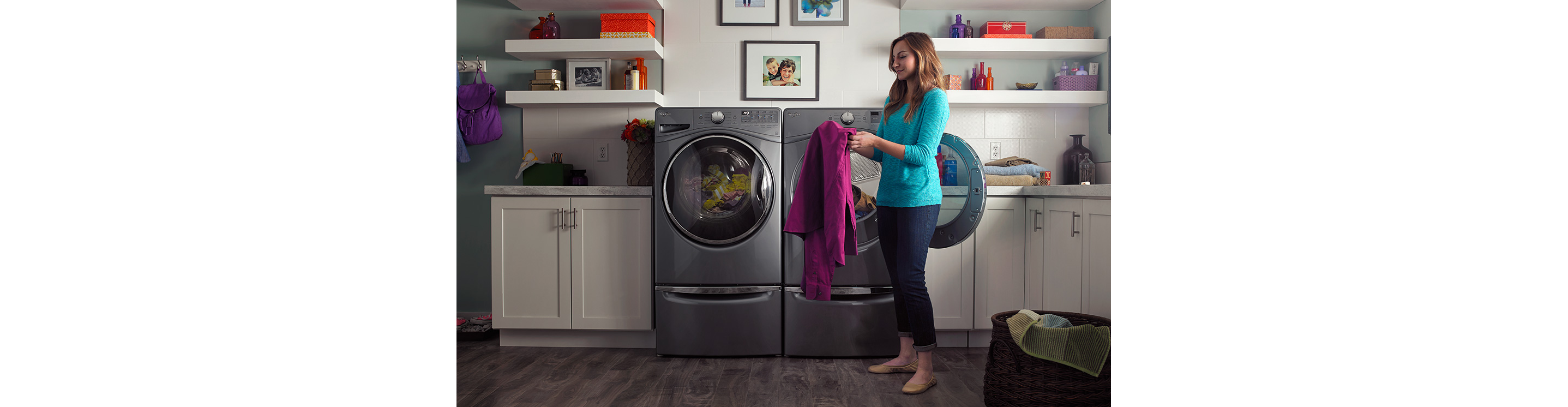 A person getting clothing out of a washer or dryer.