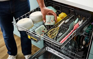 An open Whirlpool® Washing 3rd level rack with dishes arranged and ready for cleaning