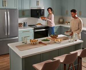 People preparing food in a modern kitchen with Whirlpool® Appliances