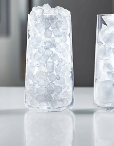 Two clear glasses with nugget ice in one and cubed ice in the other
