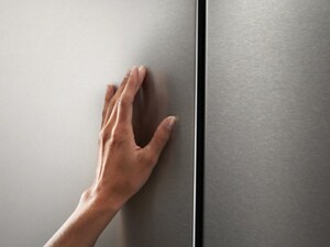 A person’s hand on a refrigerator door
