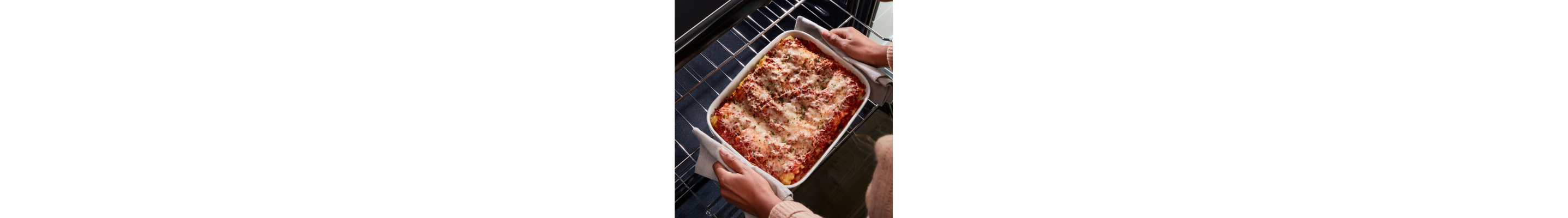 Person removing lasagna from the oven